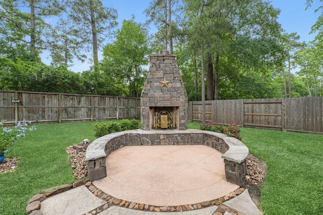 view of patio featuring an outdoor stone fireplace and a fenced backyard