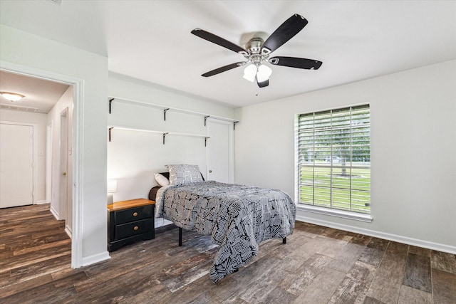 bedroom featuring dark wood-style floors, baseboards, and a ceiling fan