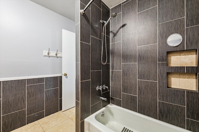 bathroom featuring tile patterned floors, wainscoting, bathtub / shower combination, and tile walls