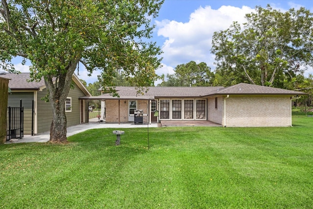 rear view of house featuring brick siding, fence, roof with shingles, a patio area, and a lawn