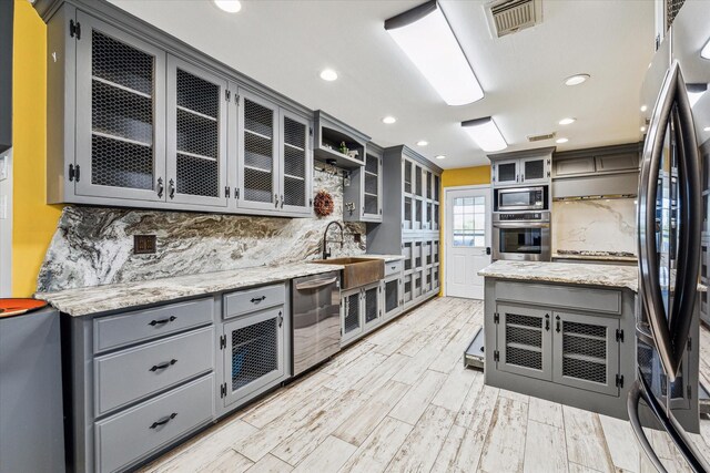 kitchen with gray cabinetry, visible vents, and appliances with stainless steel finishes