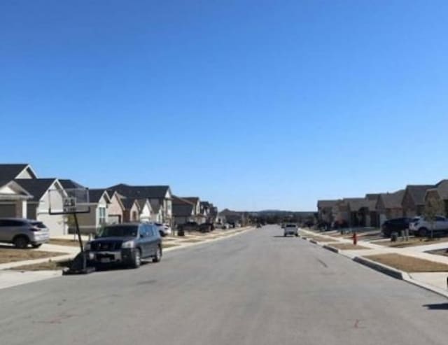view of street with curbs, sidewalks, and a residential view