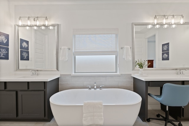 1025 Mission River Dr, Conroe, TX 77304 - bathroom featuring a freestanding tub, a sink, two vanities, and tile walls