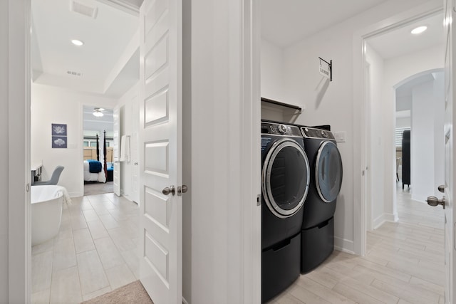 1025 Mission River Dr, Conroe, TX 77304 - washroom with recessed lighting, separate washer and dryer, laundry area, baseboards, and arched walkways