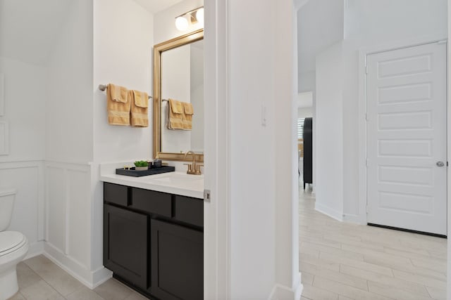 1025 Mission River Dr, Conroe, TX 77304 - bathroom featuring toilet, a decorative wall, wainscoting, and vanity