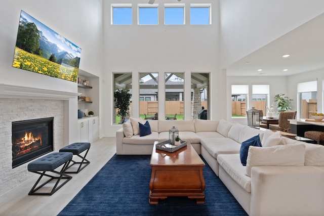 1025 Mission River Dr, Conroe, TX 77304 - living room with a glass covered fireplace, wood finished floors, built in features, and a towering ceiling