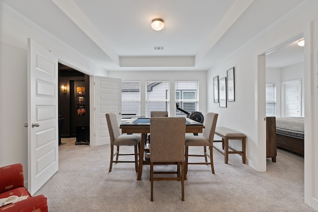 1025 Mission River Dr, Conroe, TX 77304 - dining space with visible vents, a raised ceiling, and light colored carpet