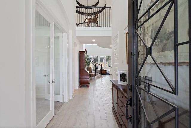 1025 Mission River Dr, Conroe, TX 77304 - foyer entrance featuring light wood-style flooring, baseboards, a towering ceiling, french doors, and stairs