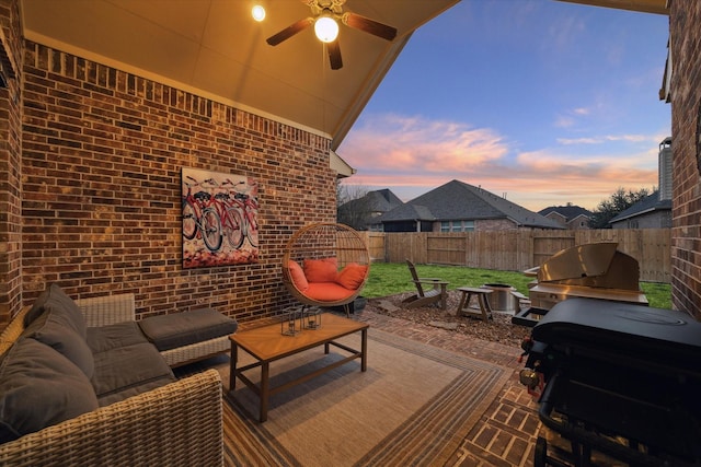 8143 Black Percher St, Conroe, TX 77385 - patio terrace at dusk featuring a fenced backyard, an outdoor hangout area, a ceiling fan, and a patio area
