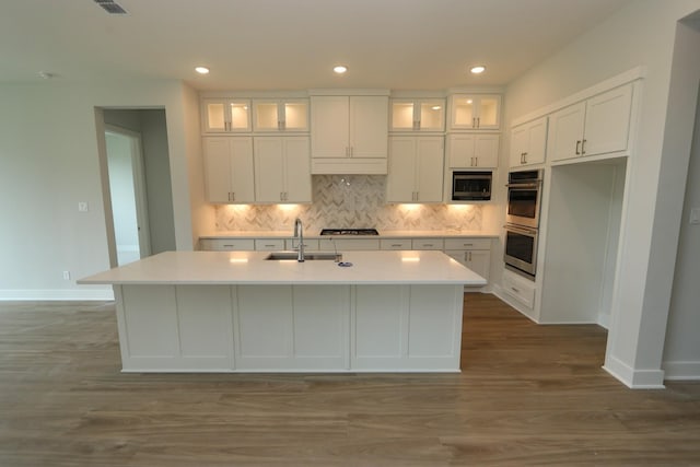 kitchen with white cabinets, stainless steel appliances, light countertops, and a sink