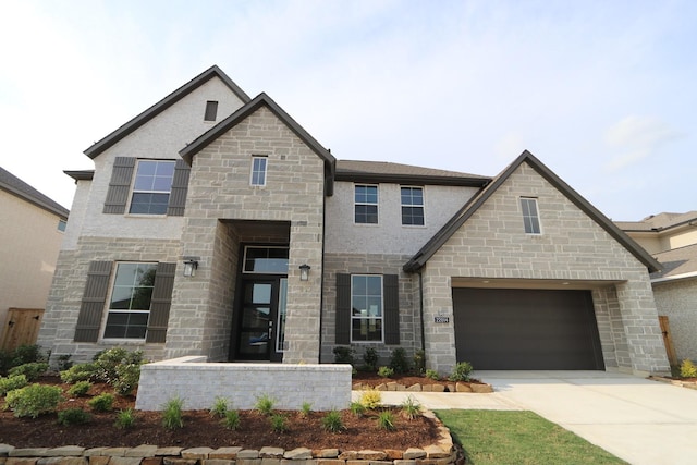 view of front facade featuring a garage, concrete driveway, and stone siding
