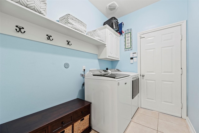 laundry room featuring separate washer and dryer, cabinet space, and light tile patterned floors