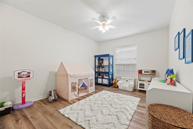 rec room with baseboards, ceiling fan, and light wood-style flooring