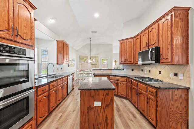 kitchen featuring stainless steel appliances, decorative backsplash, a sink, and light wood finished floors