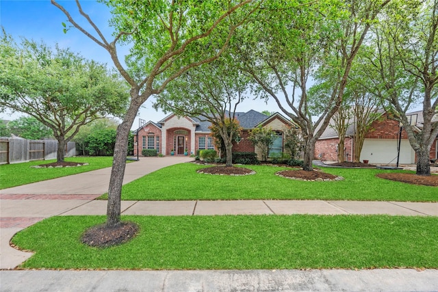 view of front of home featuring brick siding, a front lawn, fence, and concrete driveway