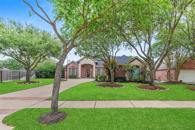 single story home featuring fence, driveway, a front lawn, and brick siding