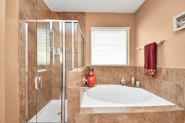 full bathroom featuring a shower stall and a garden tub