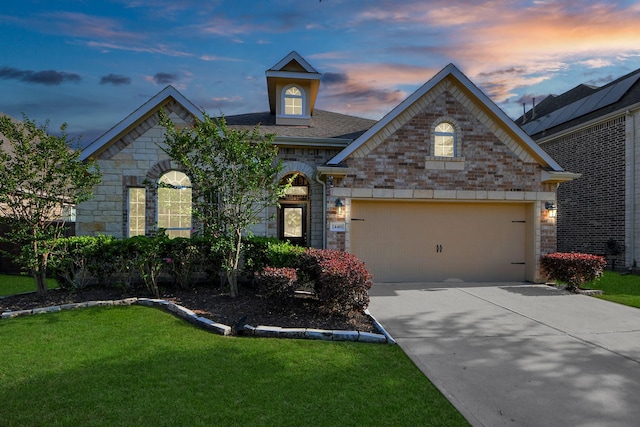 view of front of home featuring a lawn, driveway, and stone siding
