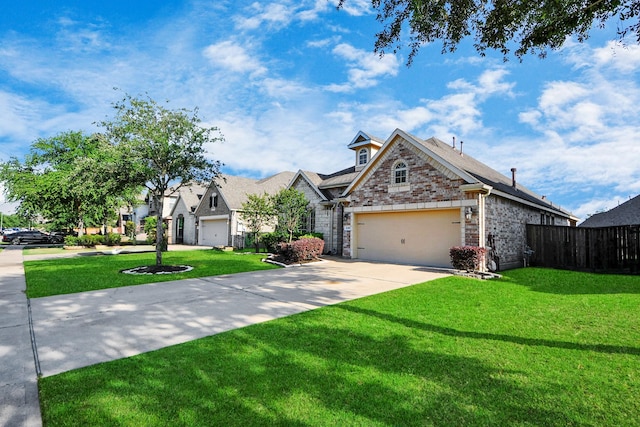 view of front of house featuring a front lawn, fence, stone siding, an attached garage, and driveway