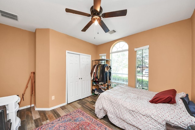 bedroom with baseboards, a closet, wood finished floors, and visible vents