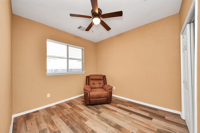 unfurnished room with baseboards, a ceiling fan, wood finished floors, and visible vents