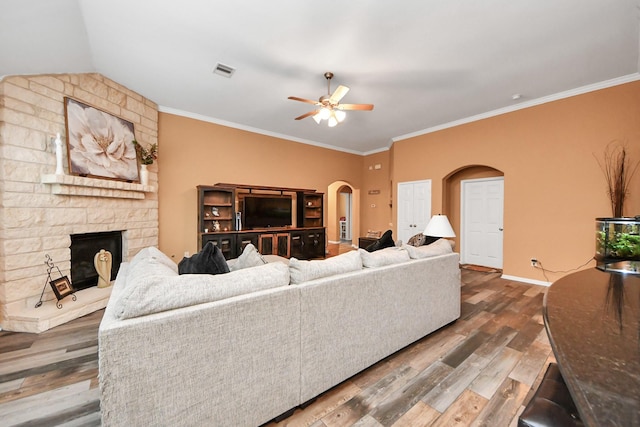 living room featuring arched walkways, ceiling fan, visible vents, and wood finished floors