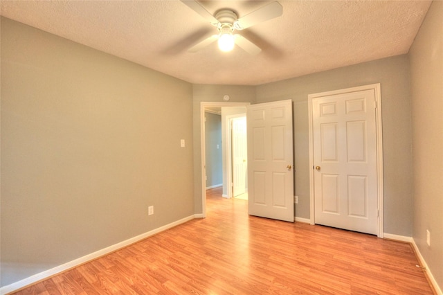 unfurnished bedroom with baseboards, a ceiling fan, a textured ceiling, and light wood finished floors