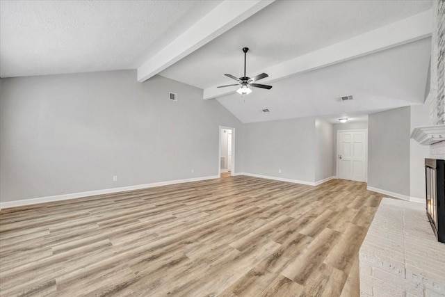 unfurnished living room featuring a fireplace, visible vents, a ceiling fan, and light wood-style flooring