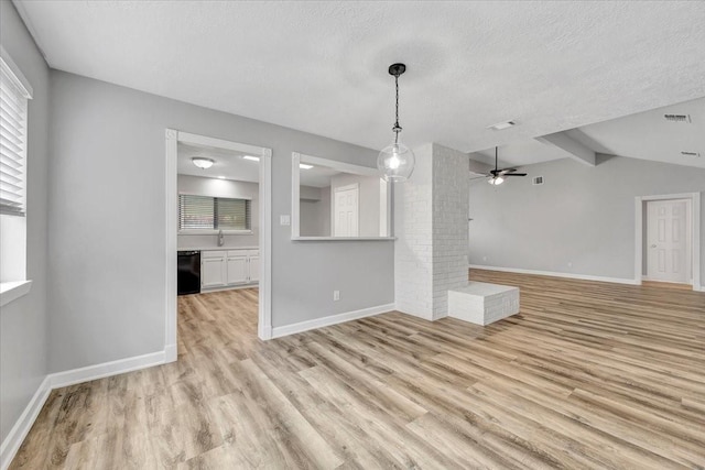 unfurnished living room featuring vaulted ceiling with beams, light wood-type flooring, visible vents, a ceiling fan, and a textured ceiling