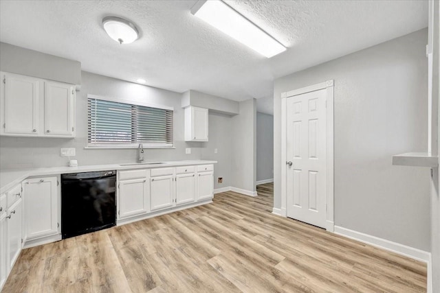 kitchen featuring a sink, black dishwasher, white cabinetry, light countertops, and a textured ceiling