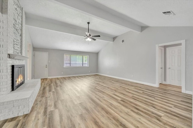 unfurnished living room featuring lofted ceiling with beams, light wood-type flooring, ceiling fan, a fireplace, and visible vents