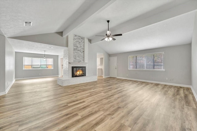 unfurnished living room featuring vaulted ceiling with beams, light wood-type flooring, ceiling fan, baseboards, and visible vents