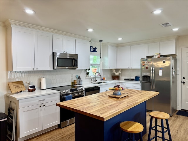 211 Southern Oaks Dr, Lake Jackson, TX 77566 - kitchen featuring light wood-style flooring, a breakfast bar area, stainless steel appliances, wooden counters, and visible vents