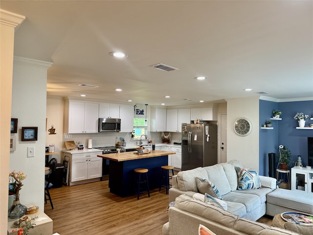 211 Southern Oaks Dr, Lake Jackson, TX 77566 - living room featuring wood finished floors, crown molding, visible vents, and recessed lighting