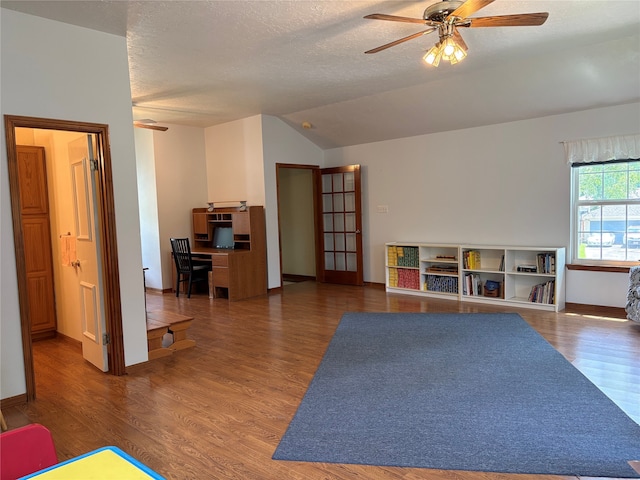 16514 Laurelfield Dr, Houston, TX 77059 - playroom with a ceiling fan, vaulted ceiling, wood finished floors, baseboards, and a textured ceiling