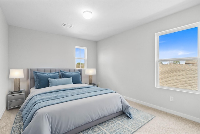 carpeted bedroom featuring visible vents and baseboards
