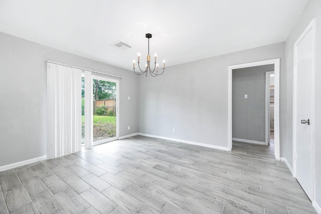 unfurnished room featuring light wood finished floors, visible vents, a notable chandelier, and baseboards