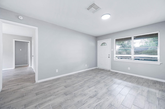 empty room featuring visible vents, baseboards, and light wood-style floors