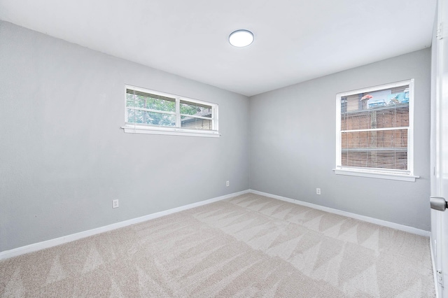 unfurnished room with carpet flooring and baseboards