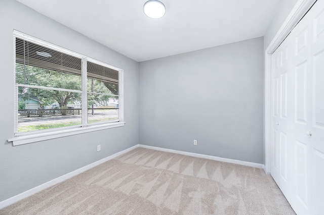 unfurnished bedroom with carpet flooring, baseboards, and a closet