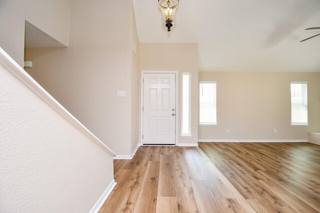 foyer entrance featuring a ceiling fan, light wood-style flooring, and baseboards