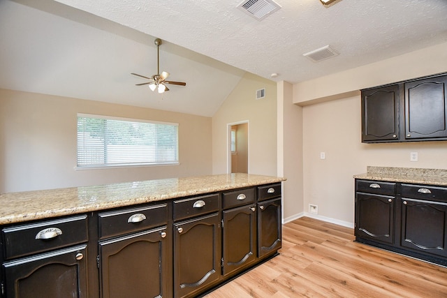 kitchen featuring visible vents, ceiling fan, light wood finished floors, and vaulted ceiling