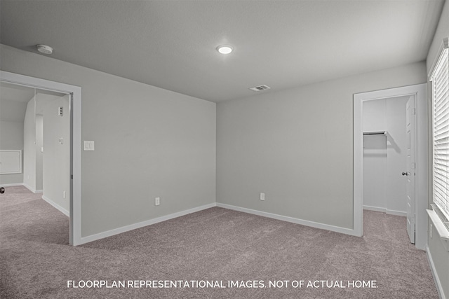 unfurnished bedroom with a spacious closet, carpet flooring, and baseboards