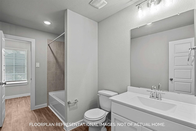 bathroom featuring vanity, toilet, visible vents, baseboards, and wood finished floors