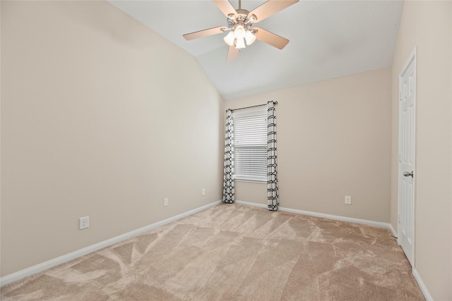 empty room featuring ceiling fan, baseboards, vaulted ceiling, and carpet floors