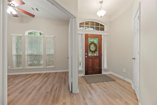 entrance foyer with baseboards, visible vents, ceiling fan, and light wood-style floors
