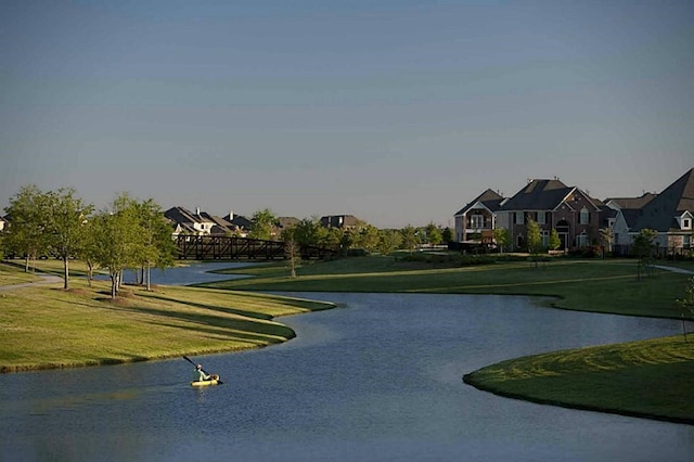 exterior space featuring a yard, a water view, and a residential view