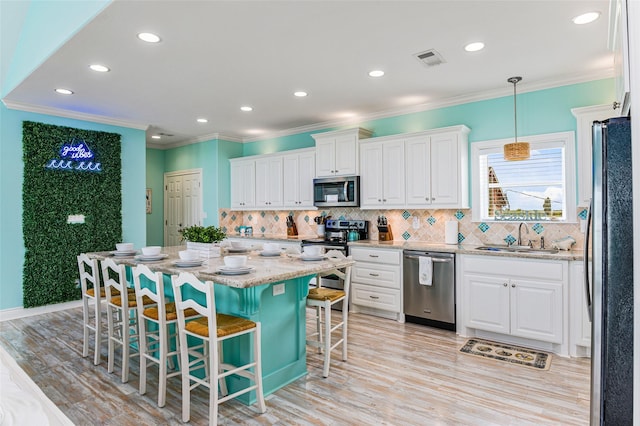 3347 Prides Way, Crystal Beach, TX 77650 - kitchen with white cabinetry, a sink, appliances with stainless steel finishes, visible vents, and ornamental molding