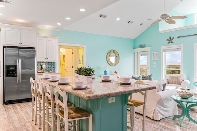 3347 Prides Way, Crystal Beach, TX 77650 - kitchen featuring white cabinetry, visible vents, stainless steel fridge, and light wood-style floors