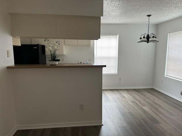 12660 Ashford Point Dr Unit 403, Houston, TX 77082 - kitchen featuring a textured ceiling, a chandelier, freestanding refrigerator, and wood finished floors